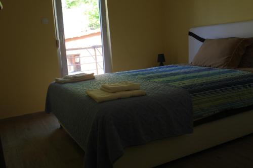 a bedroom with a bed with two towels on it at Apartments Kapisoda in Cetinje