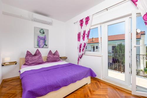 a bedroom with a purple bed and a large window at Villa Laura in Vantačići