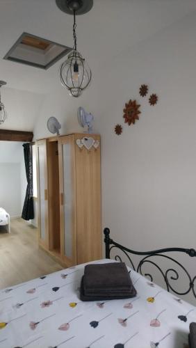 une chambre avec un lit avec une couverture dessus dans l'établissement Le Petit Soleil, à Isserpent