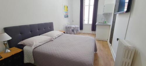 a bedroom with a large bed with a blue headboard at SeaYouSoon Inn Cannes - Studios in Cannes