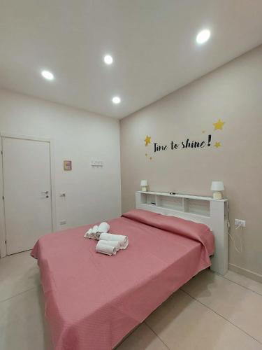 Un dormitorio con una cama rosa con un animal de peluche. en NapoliDream Bed and Breakfast, en Nápoles