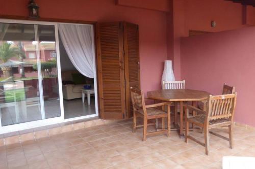 a dining room with a wooden table and chairs at Casa Atalanta - huis met zwembad in Albatros 2 in Mar de Cristal