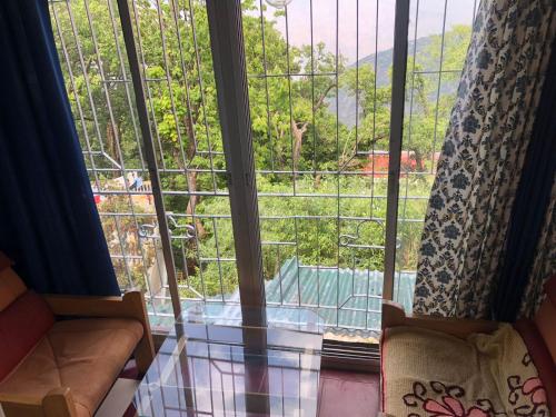 a room with a large window with a view at Jindal Home stay mussoorie in Mussoorie