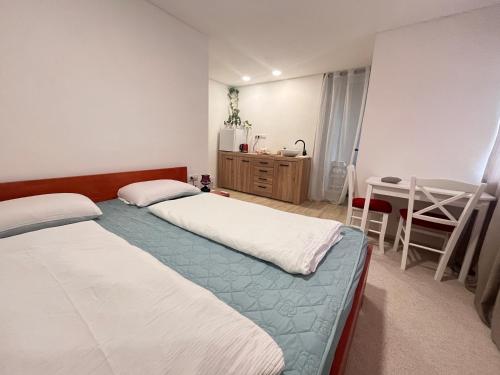 2 camas en una habitación con mesa y escritorio en Apartmán Monstera II en Kolín