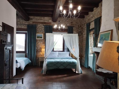 a bedroom with a bed and a chandelier at Agriturismo Casa Rastelli in Monteorsello