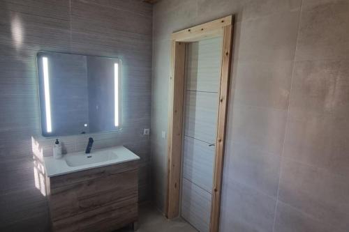 uma casa de banho com um lavatório, um espelho e um chuveiro em Chalet Montes de Llanorel em Valência