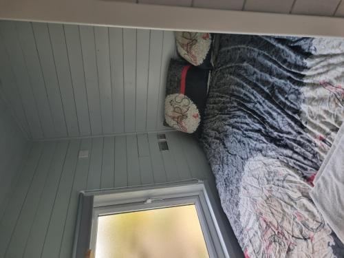 a small bedroom with a bed and a mirror at Glamping Hut - Riverview 3 in Welshpool