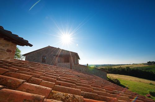 a sun shines over the roof of a house at Agriturismo Gattogiallo in Montegabbione