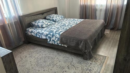 Un dormitorio con una cama con almohadas. en Жана кала, 11-ая улица, 3-х комнатная квартира, en Tridtsatʼ Let Kazakhstana