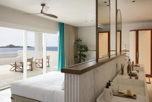 a bedroom with a bed and a large mirror at Nammos Hotel Mykonos in Psarou