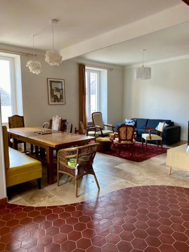 un salon avec une table et des chaises en bois dans l'établissement Gîte de la maison jaune - Comblanchien, à Comblanchien