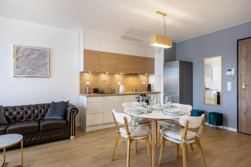 eine Küche und ein Esszimmer mit einem Tisch und Stühlen in der Unterkunft 04 Gdynia Premium - Apartament Mieszkanie dla 2 osób z parkingiem in Gdynia