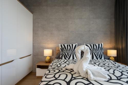 Ein weißer Schwan sitzt auf einem Bett in der Unterkunft 04 Gdynia Premium - Apartament Mieszkanie dla 2 osób z parkingiem in Gdynia