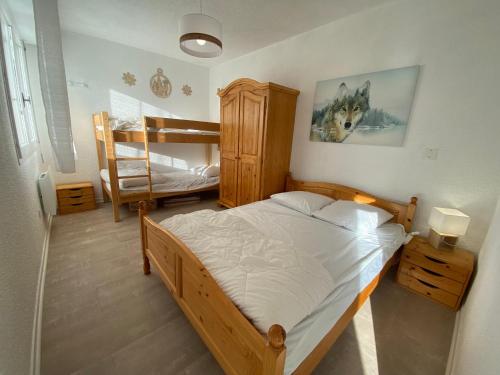 雷魯斯的住宿－Le Chalain cosy proche centre ville，一间卧室配有一张床和一张双层床。