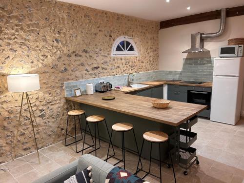 a kitchen with a table and stools in it at Gîte de L'Oliviade - Campagne & Confort in Billancelles