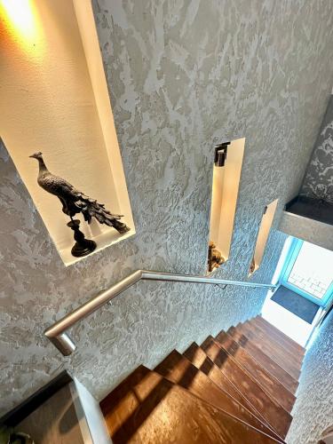 a staircase with a bird picture on the wall at Country Haven Comfy & Sleek Apartment in Kildare