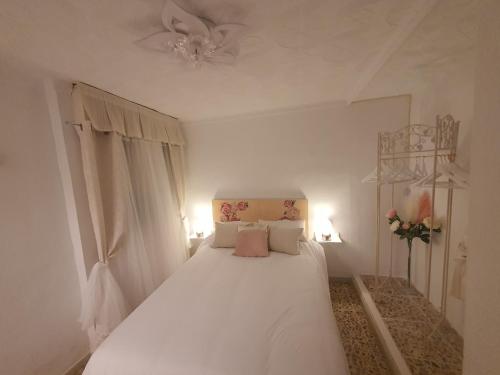 a white bedroom with a bed with white sheets and pillows at Adorable Apartamento en la Playa in Puerto de Mazarrón