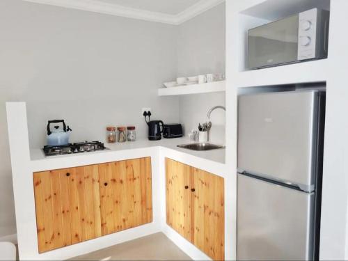 a kitchen with wooden cabinets and a refrigerator at Hartshuijs in Beaufort West