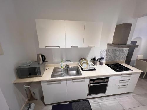 a white kitchen with a sink and a microwave at Ebene Square apartment in Trianon