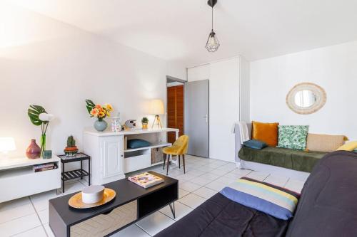 een woonkamer met een bank en een tafel bij Le Clos des Rosiers in Toulouse