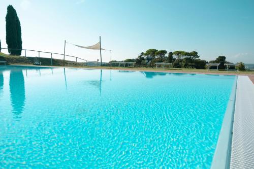 a large pool of blue water with a flag at Agriturismo Cheloni in Guasticce