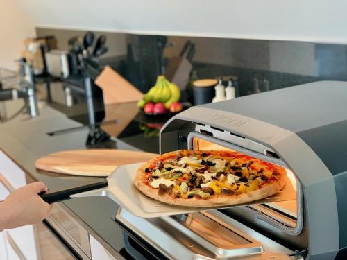 Una pizza está saliendo de un horno en Luna o Mountainview o Pizzaoven, en Brunnen