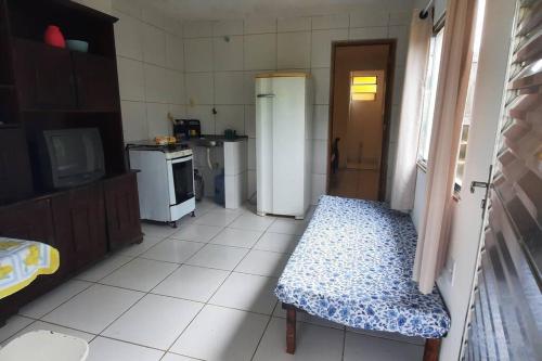 een keuken met een koelkast en een tafel. bij kitnet Bela Vista in Maricá