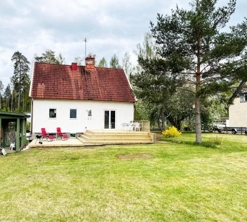 een wit huis met een terras en een rood dak bij Villa with 4 bed rooms with internet in Vimmerby in Gullringen