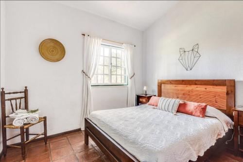 a bedroom with a bed and a window at Casa da Falésia in Melides