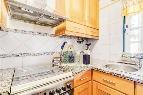 a kitchen with wooden cabinets and a sink at Casa da Falésia in Melides