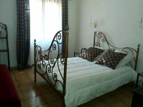 - une chambre dotée d'un grand lit avec un cadre métallique dans l'établissement The Secret Garden, à Rodès