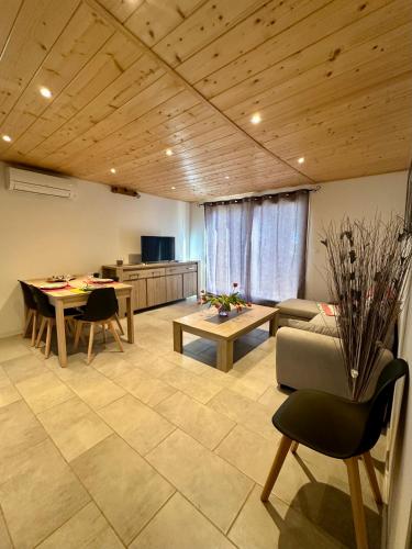 un salon avec une table, des chaises et un canapé dans l'établissement Le Gîte des poiriers, à Uzès