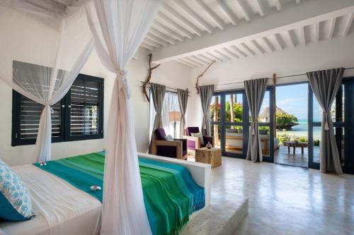 a bedroom with a bed with a view of the ocean at Upendo Beach Boutique Hotel Zanzibar in Michamvi