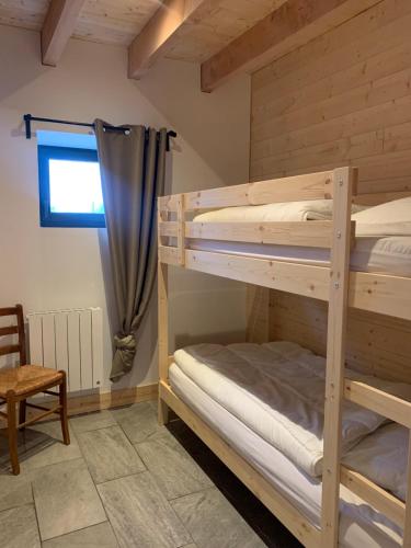 1 Schlafzimmer mit 2 Etagenbetten und einem Stuhl in der Unterkunft Gîte du Redondet 
