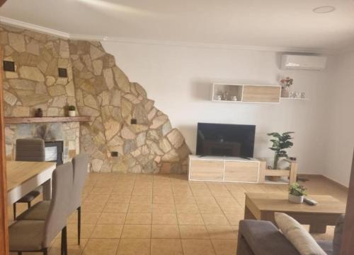 sala de estar con pared de piedra en Casa piscina, en Chiclana de la Frontera