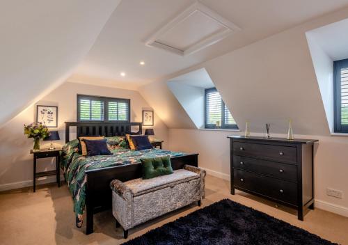 a bedroom with a bed and a chair and windows at Autumn Barn Annexe in Smarden