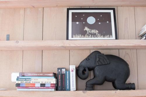 une étagère avec un éléphant en peluche et des livres dans l'établissement Grand Trianon, Clim - Terrasse, à Arles