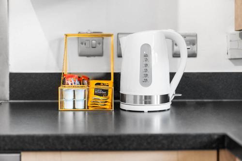 a white appliance sitting on a kitchen counter at 2 Bedroom House - Garden & Parking 2GM - Wifi in Birmingham