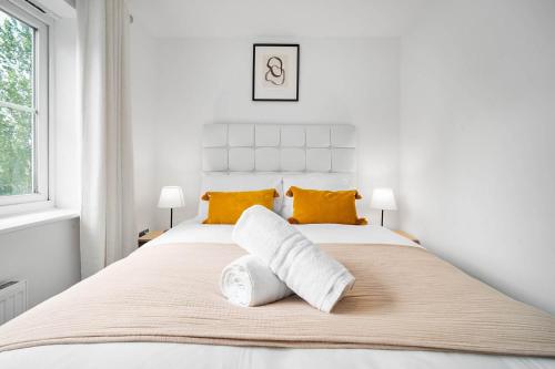 um quarto branco com uma cama grande e almofadas amarelas em 2 Bedroom House - Garden & Parking 2GM - Wifi em Birmingham