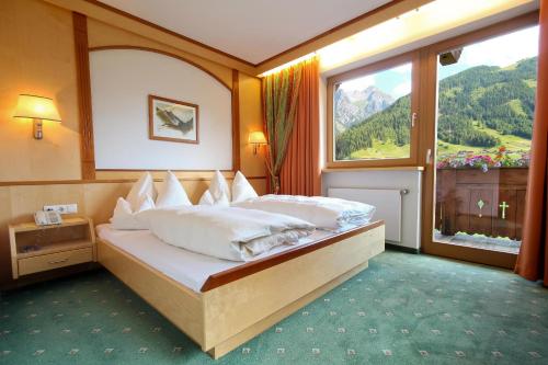 a bedroom with a bed with a large window at Ladestatthof in Neustift im Stubaital