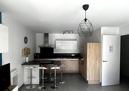 een keuken met krukken in het midden van een kamer bij Douceur en Ville Saint Raphel in Saint-Raphaël