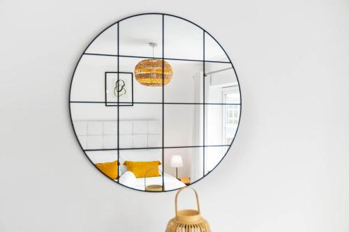 a mirror hanging on a wall with a yellow couch at 2 Bedroom House - Garden & Parking 2GM - Wifi in Birmingham