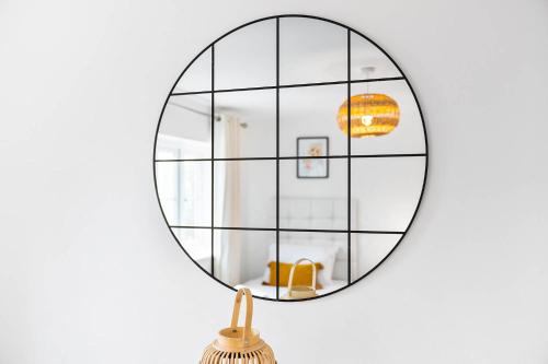 a round mirror hanging on a wall with a broom at 2 Bedroom House - Garden & Parking 2GM - Wifi in Birmingham