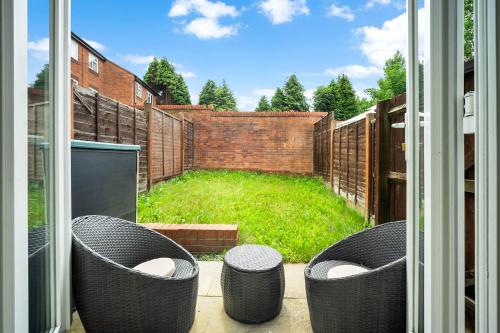 um pátio com cadeiras de vime e um jardim fora de uma janela em 2 Bedroom House - Garden & Parking 2GM - Wifi em Birmingham