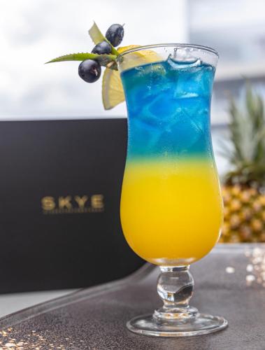 a colorful drink in a glass sitting on a table at Coastlands Skye Hotel, Ridgeside, Umhlanga in Durban