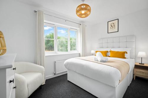 a white bedroom with a bed and a chair at 2 Bedroom House - Garden & Parking 2GM - Wifi in Birmingham