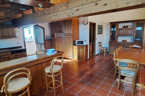 a kitchen with a counter and a table and chairs at Attico con vista sulle Dolomiti in Calalzo