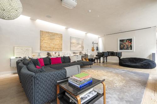 ein Wohnzimmer mit einem Sofa und einem Tisch in der Unterkunft JOIVY Architectural gem with pool and terrace in West London in London