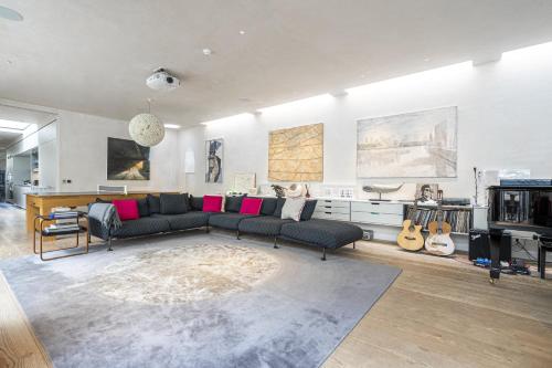 ein Wohnzimmer mit Sofa und Gitarren in der Unterkunft JOIVY Architectural gem with pool and terrace in West London in London