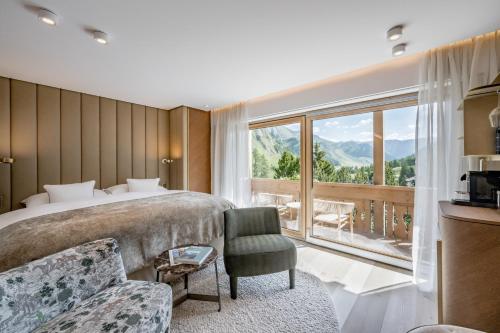 1 dormitorio con cama y ventana grande en Relais & Châteaux Chasa Montana en Samnaun